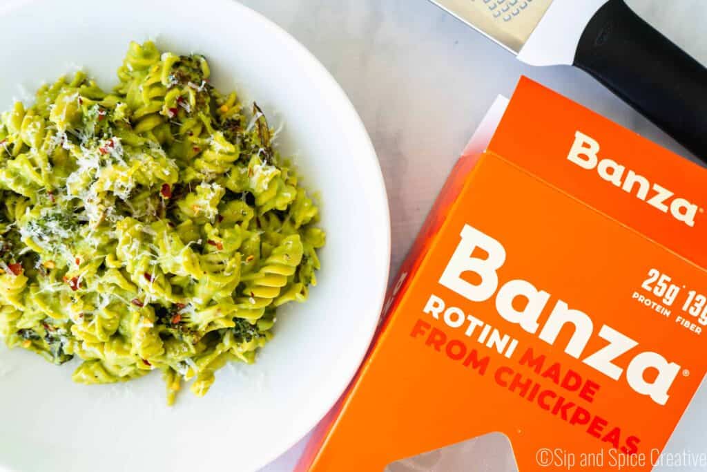 bowl of broccoli pasta next to empty box of banza pasta