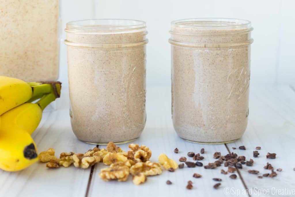 two vegan chunky monkey smoothies in mason jars with bananas, walnuts and cacao nibs