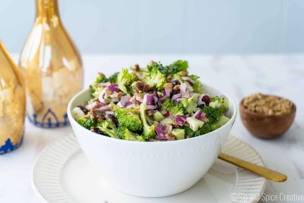 Finished broccoli salad in a white bowl with sunflower seeds