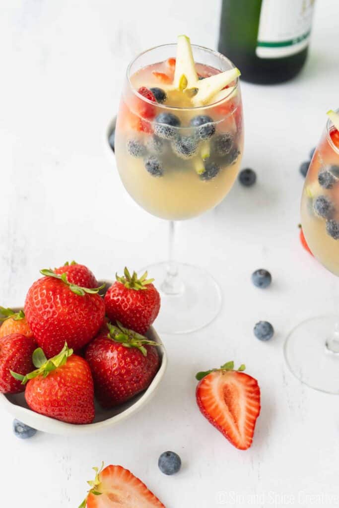 red white and blue mimosas with bowl of strawberries