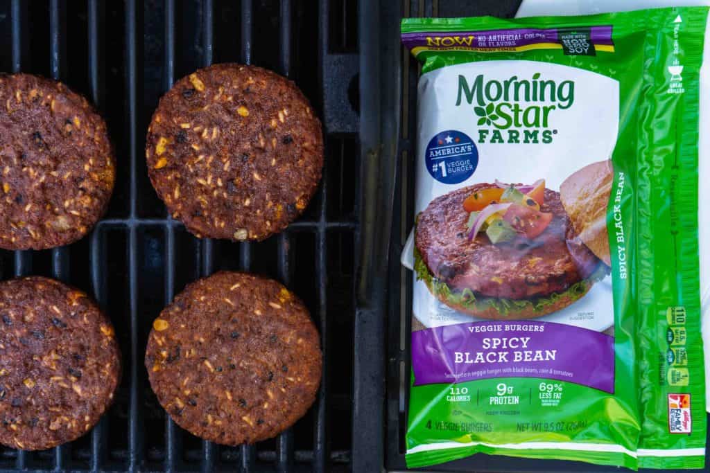 black bean burgers on the grill next to their packaging