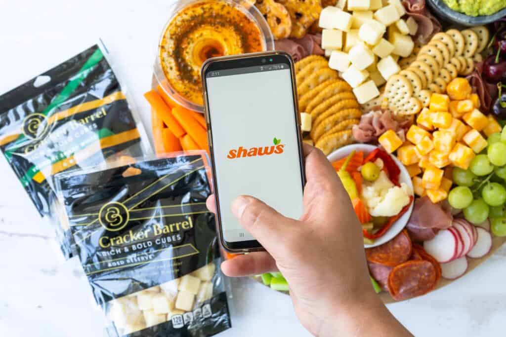 Shaws app over cheese board with cracker barrel cheese cube packaging