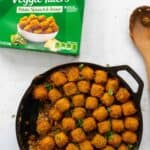 shepherd's pie in a cast iron skillet with tater tots on top with mccain tater tot packaging on the side