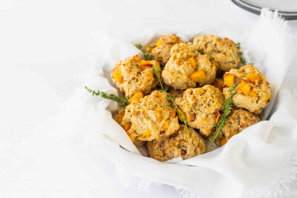 basket of peach scones with thyme sprigs and a white cloth napkin