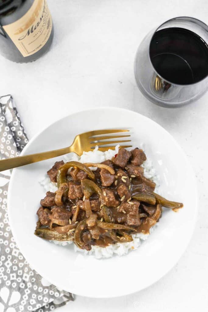Final Image of Easy Italian Pepper Steak and Rice with Wine with gold fork and glass of wine