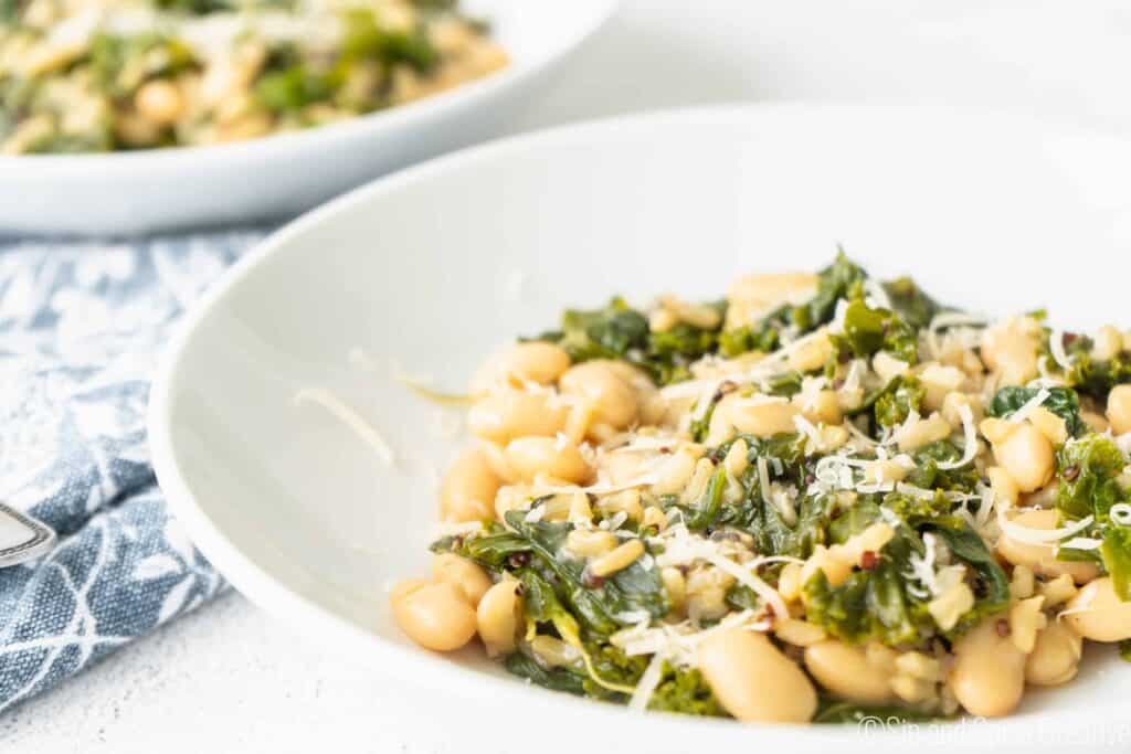 greens and beans risotto in a white bowl