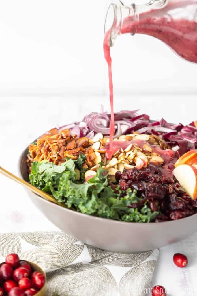 Cranberry Vinaigrette pouring on Kale and Radicchio Salad