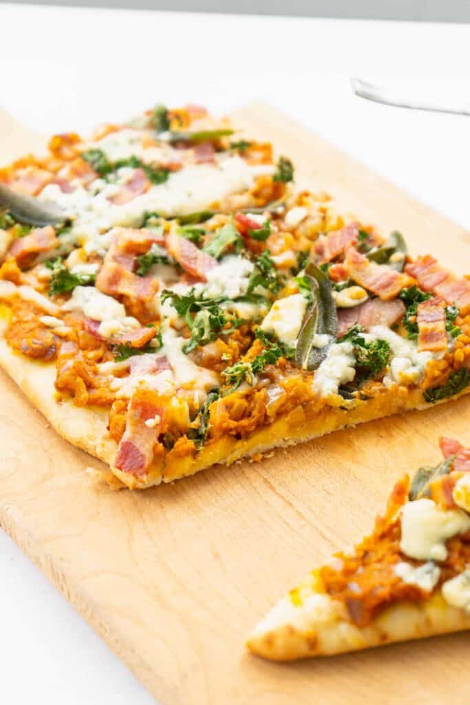 Savory Pumpkin Flatbread with Bacon, Sage and Blue Cheese on a wooden board