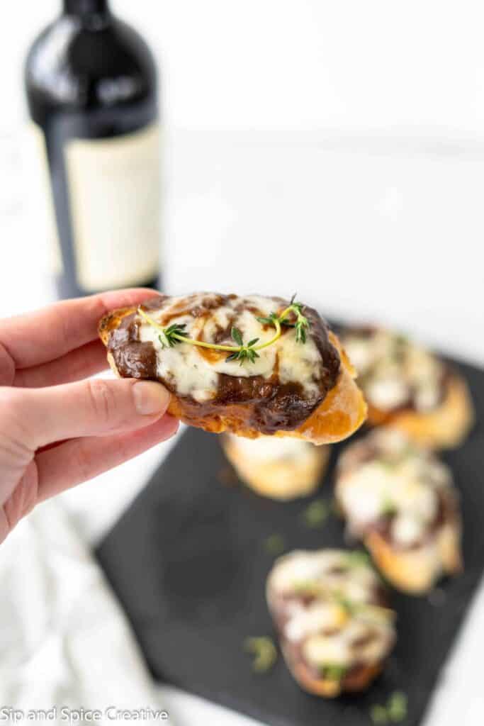 hand holding one French Onion Crostini 