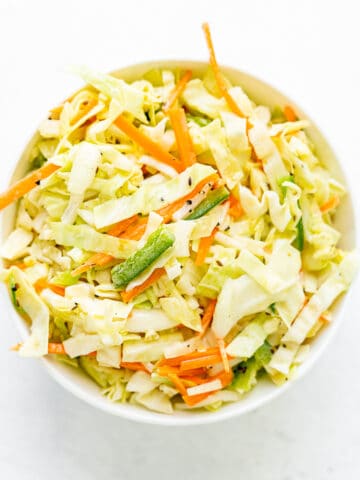 Top down view of coleslaw in white bowl on white background