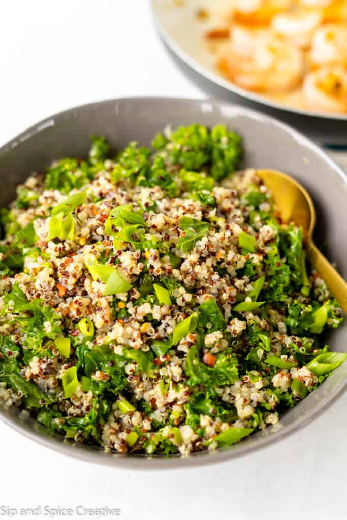 Kale Quinoa Salad in a grey bowl with a gold spoon