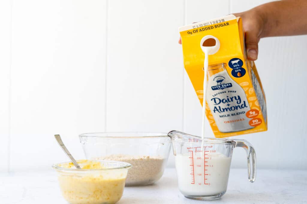 milk pouring from a carton into a measuring cup